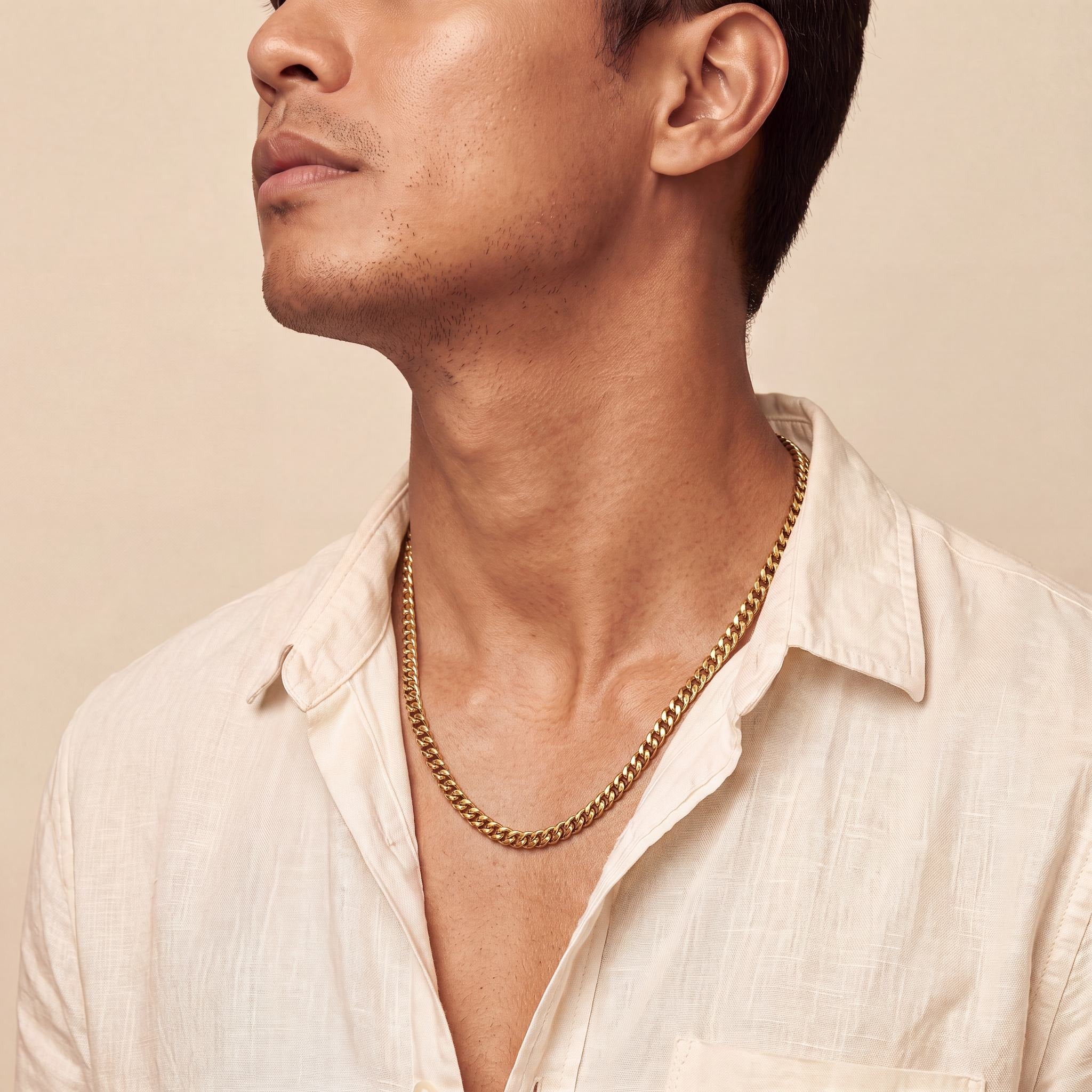 Man wearing a 10K yellow gold Ethos Essence Cuban chain necklace, 4.6mm